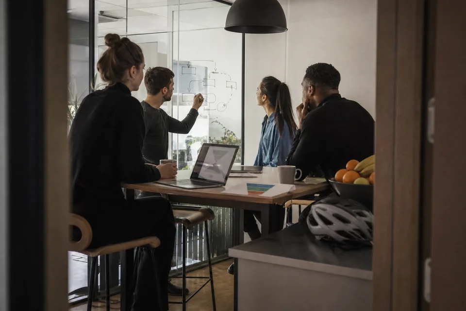 Growth team looking at a revenue dashboard on a meeting room screen