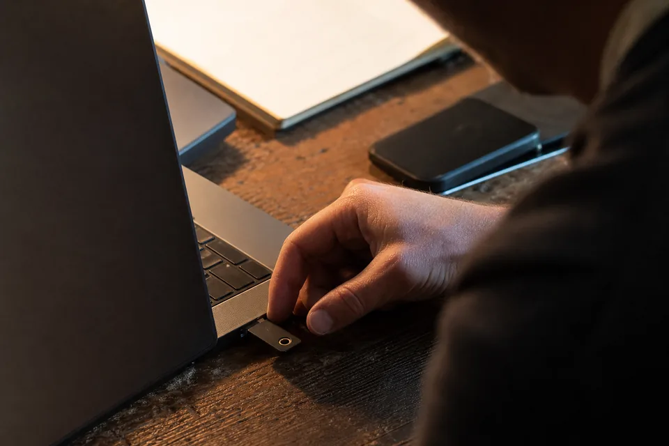 Hands on a laptop adjusting access settings in a quiet office